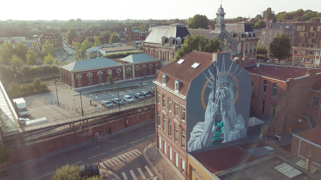 A mural depicting the Statue of Liberty covering her face in shame appeared on a building in Northern France over Independence Day weekend and quickly garnered millions of views on social media. “The Statue of Liberty’s Silent Protest,” by Dutch street artist Judith de Leeuw, was unveiled on July 4 in the city of Roubaix just as President Trump geared up to sign his so-called “Big Beautiful Bill,” which includes sweeping cuts to programs like Medicaid.
