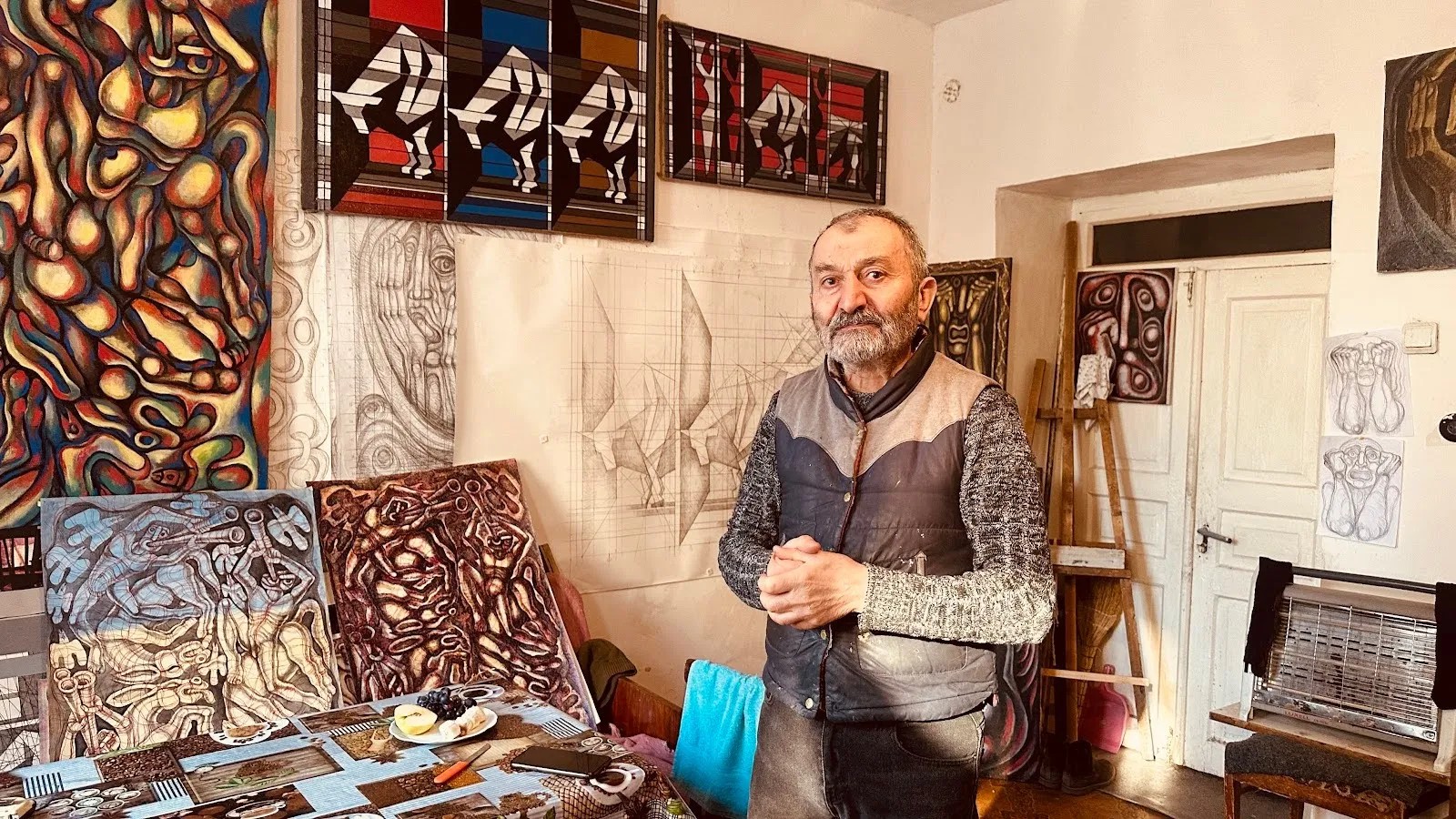 Arnold Meliksetyan，76，a painter and sculptor，in a small living space that doubles as his studio (photo Siranush Sargsyan/Hyperallergic)