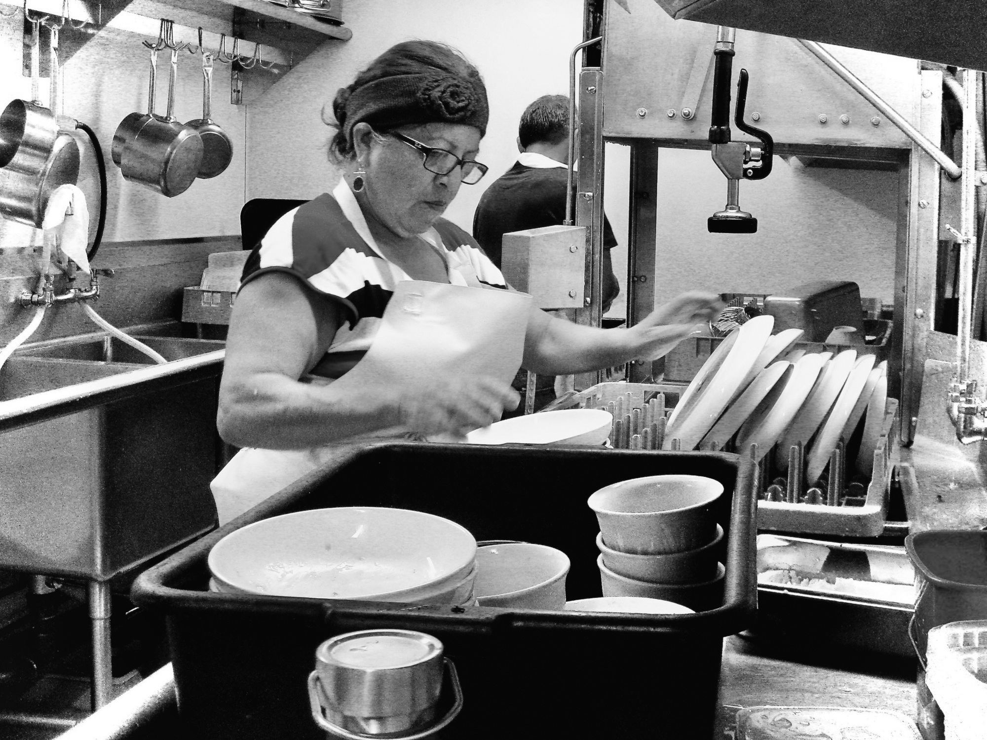 生於厄瓜多的布蘭卡．巴斯奎茲（Blanca Vasquez），移居至美國後從事洗碗工。圖為她在位於芝加哥的緣滿餐廳地下室專心工作。（圖片來源／二十張出版提供）