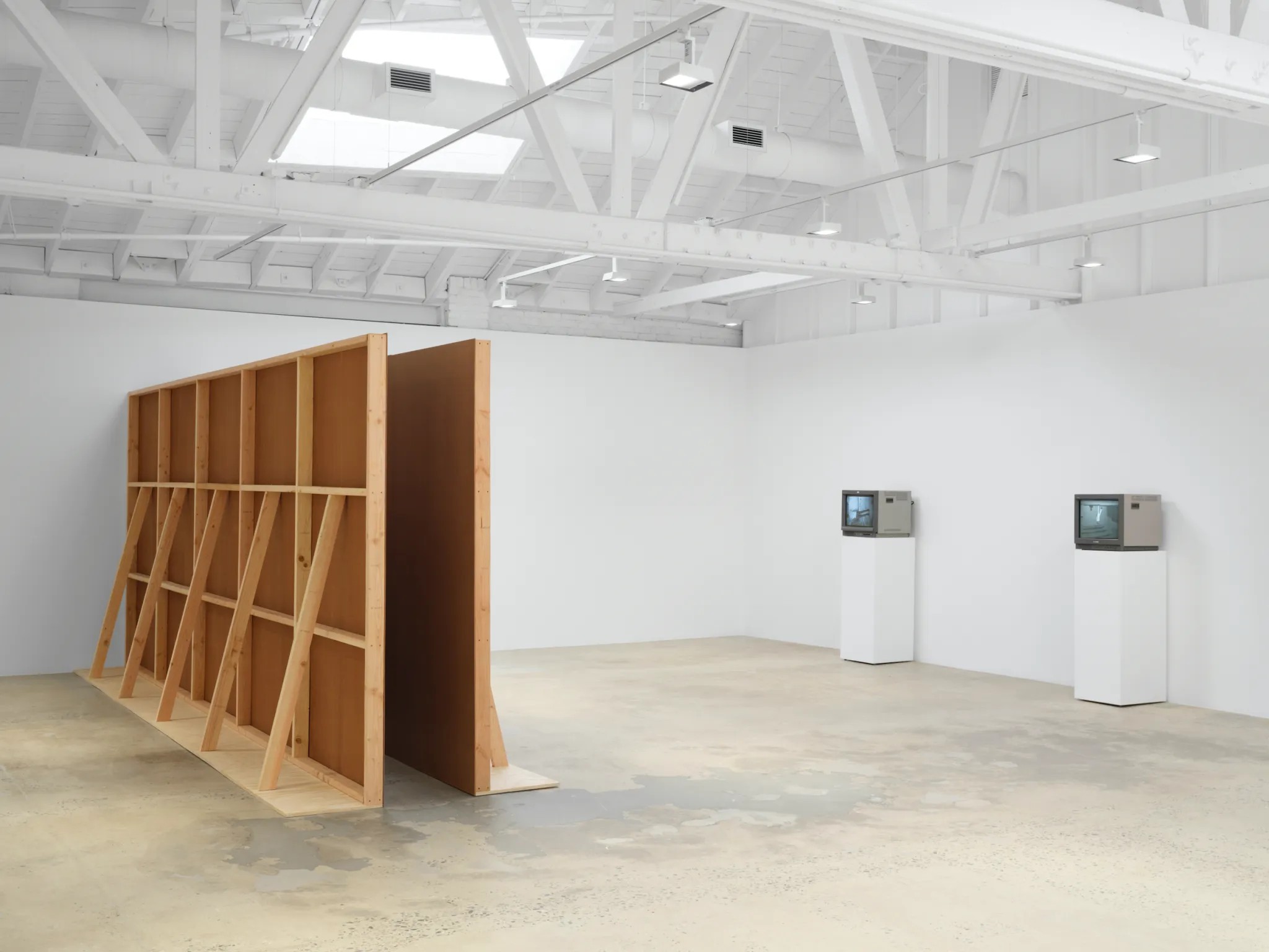 Installation view of Bruce Nauman: Pasadena Years at Marian Goodman Gallery，Los Angeles. Left to right: “Performance Corridor” (1969); wallboard and wood; “Violin Tuned D.E.A.D.” (1969)，videotape，black and white，sound，60 min.，to be repeated continuously; “Revolving Upside Down” (1969)，videotape，black and white，sound，60 min.，to be repeated continuously