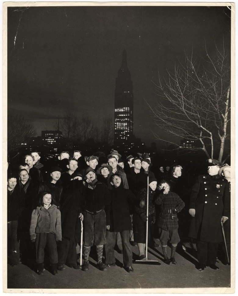 Weegee，“Night… a black velvet curtain has dropped over the white sky… a few mothers went looking for their kids… found them here… dragged them home for supper… but they are back again… but that’s the same Empire State Building in the Background….，” (1944)，photograph