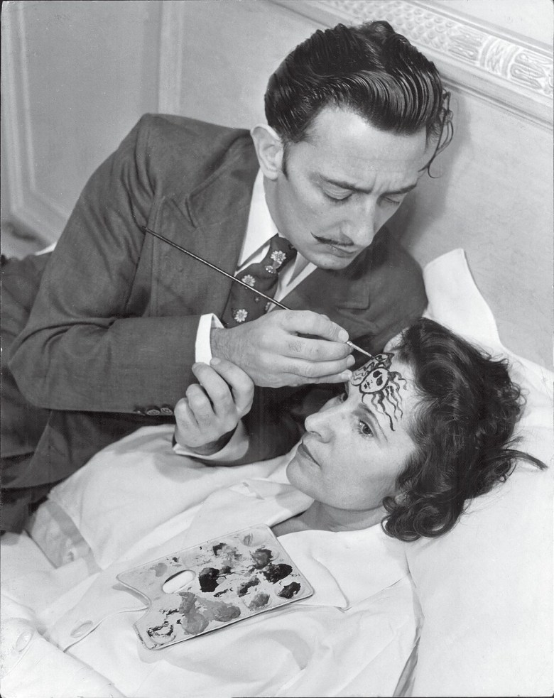 Gala asked Philippe Halsman to photograph her and Salvador in 1942. The original Toronto Star caption to the photo，taken in their suite at the St. Regis Hotel in New York，reads: “On his wife’s forehead，Salvador Dali paints the head of Medusa，one of the three snaky-haired Gorgon sisters whose glance turned into stone everything on which it rested. Mrs. Dali looks serious，as well she might，at the thought of carrying wherever she goes a threat like that.” (image via Getty Images，courtesy Harper)