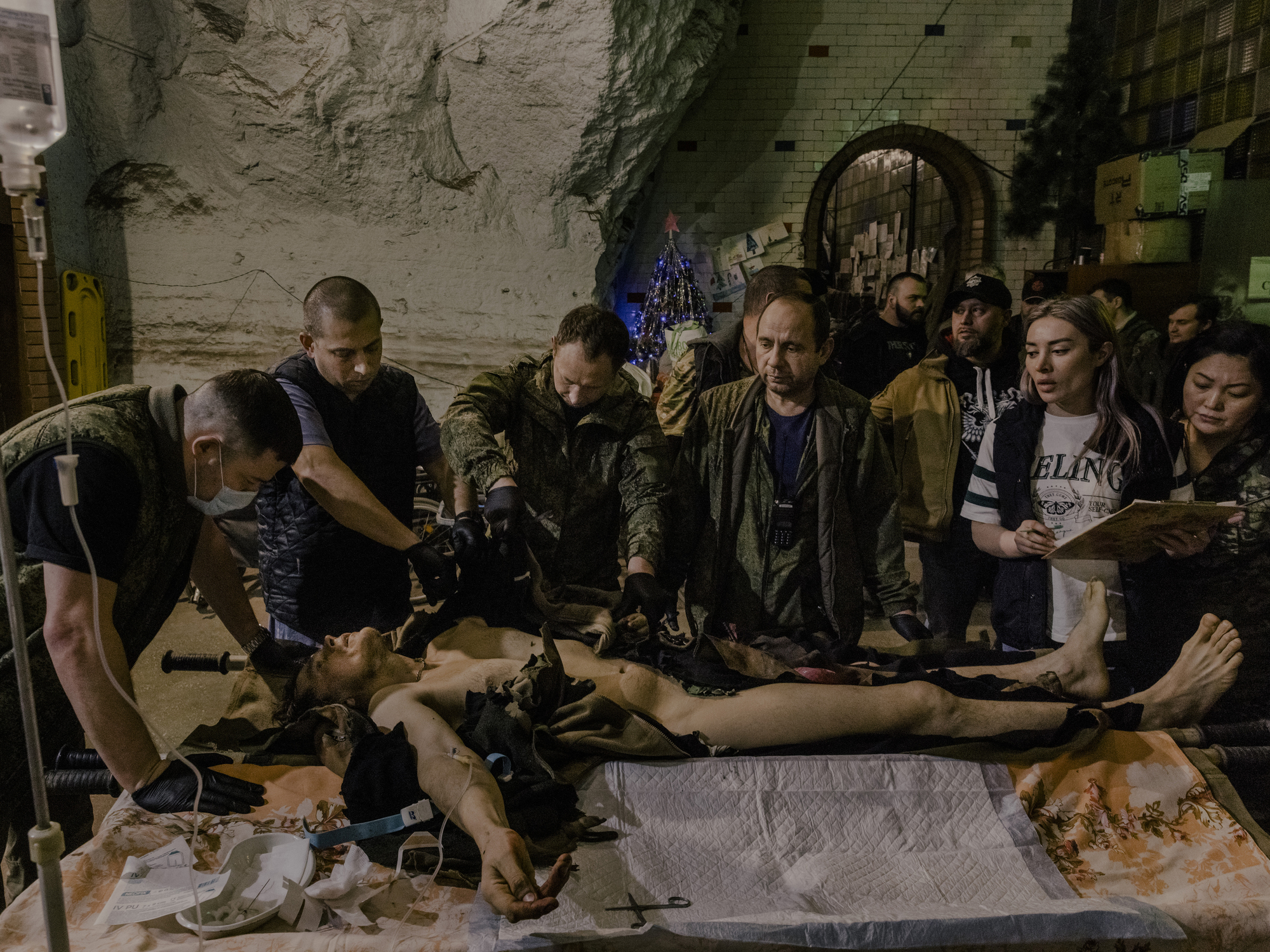 2024年1月22日，烏克蘭頓巴斯（Donbas）地區，一名在巴赫木特（Bakhmut）附近受傷的士兵，躺在由地下酒廠改建的臨時醫療站。其左手與左腿後來皆被截肢。（攝影／Nanna Heitmann／Magnum Photos／The New York Times)