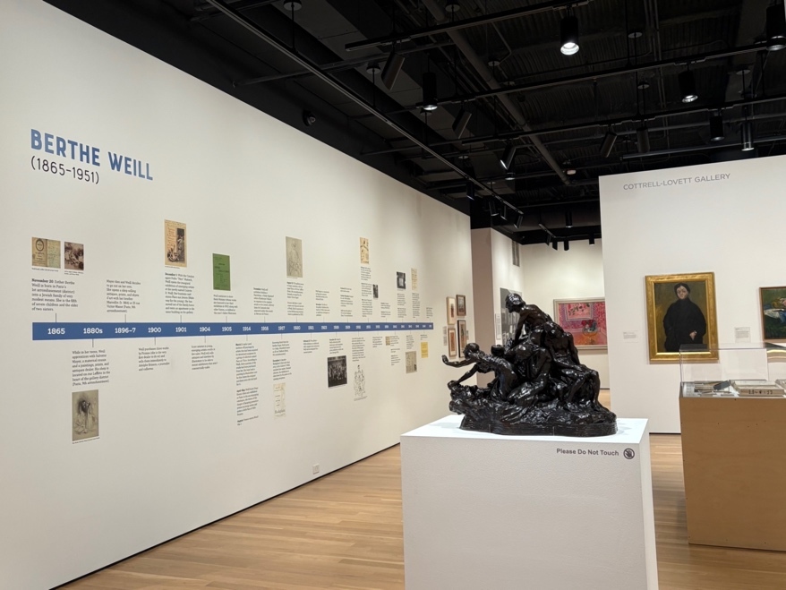 展览入口处的巨大展板，用生命线的形式标注了韦尔的大事年表。右边墙上，是韦尔的密友艾米莉·查米为她绘制的肖像，大量的黑色凸显了独立职业女性的气势，相当现代。后面墙上的粉色大图是杜菲的“三十年或者生活与玫瑰”。（本文图片悉由作者拍摄）